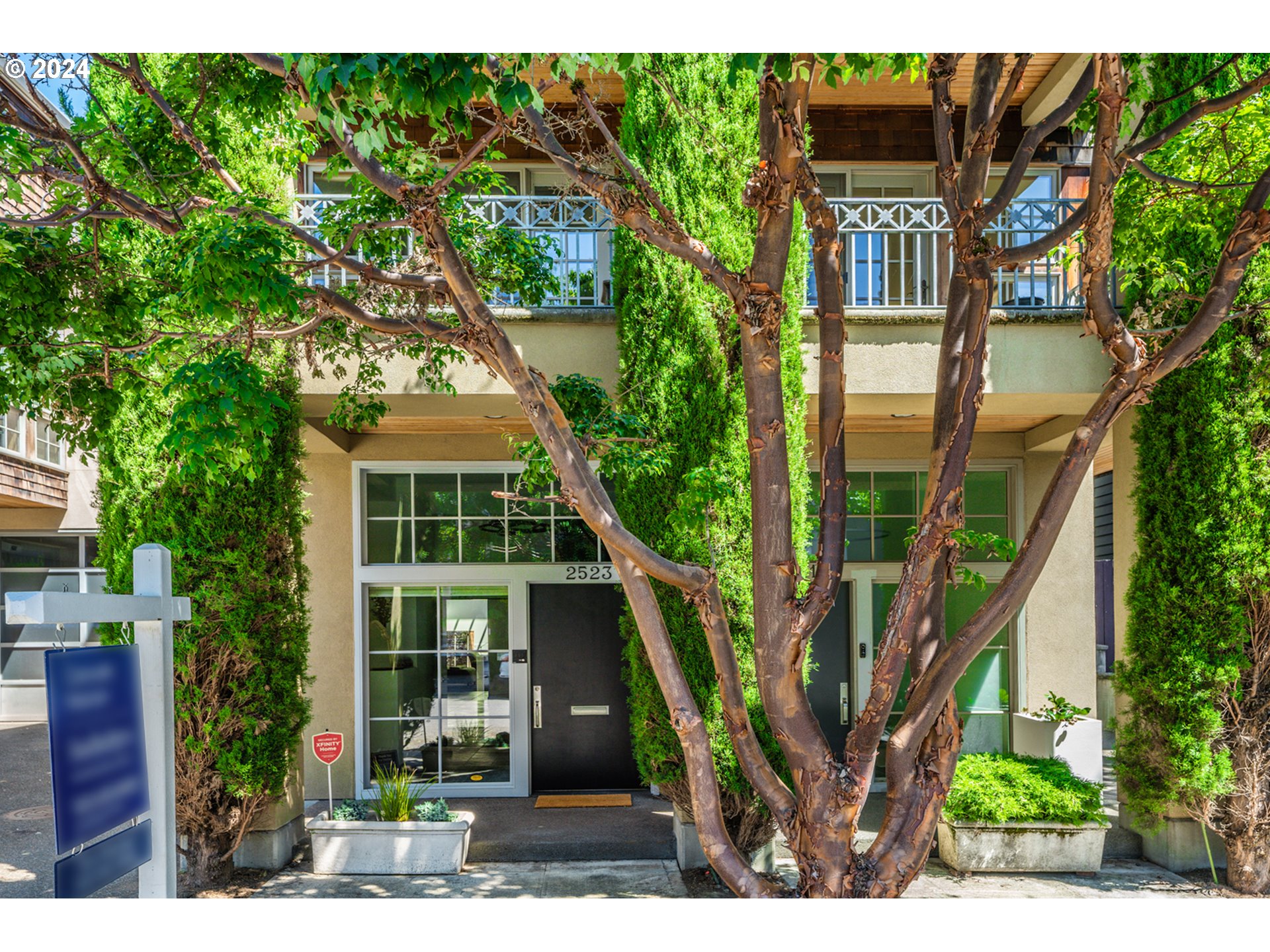 a front view of a house with a tree