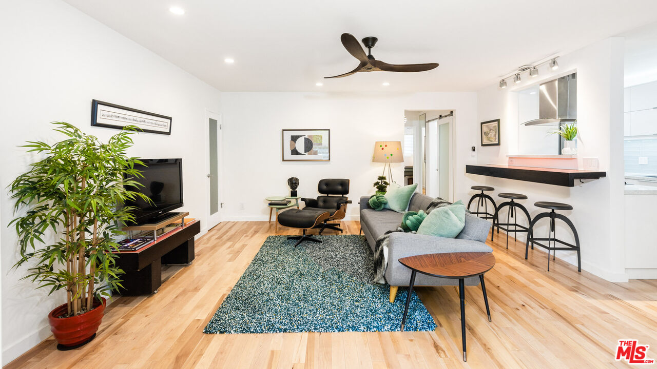 a living room with furniture a flat screen tv and a potted plant