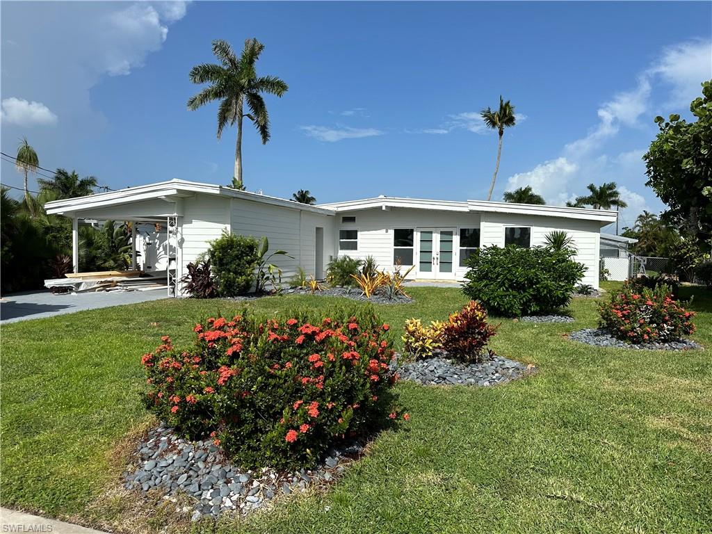 a front view of a house with a garden and plants