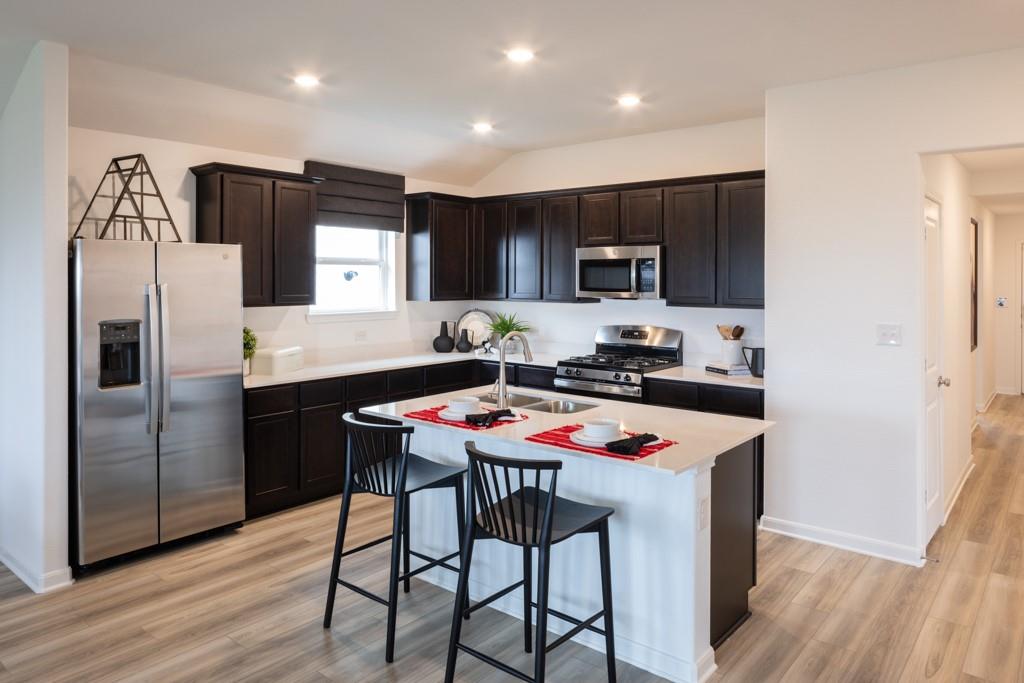 a kitchen with stainless steel appliances granite countertop a refrigerator and a stove top oven