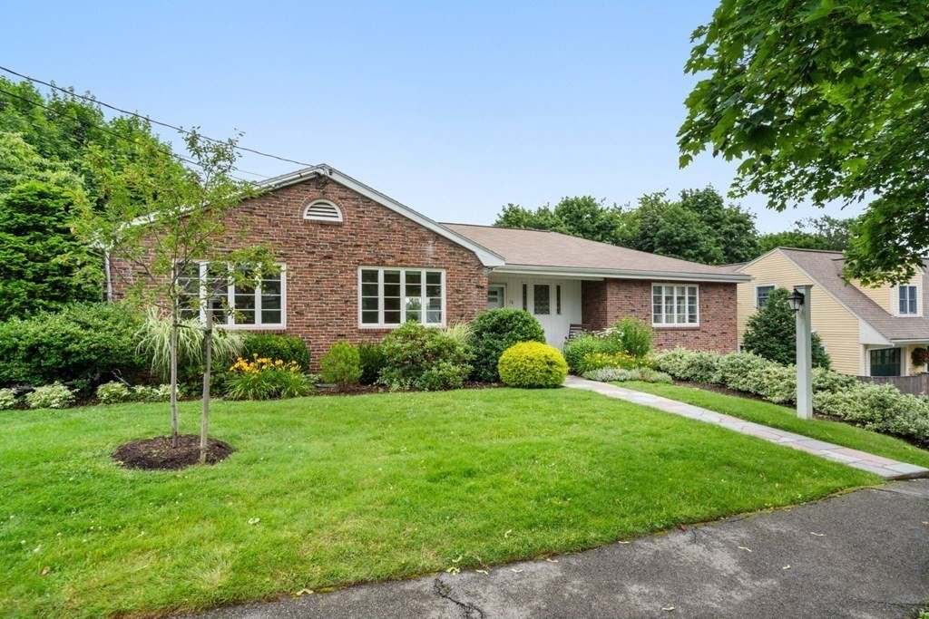 a front view of a house with a yard and trees