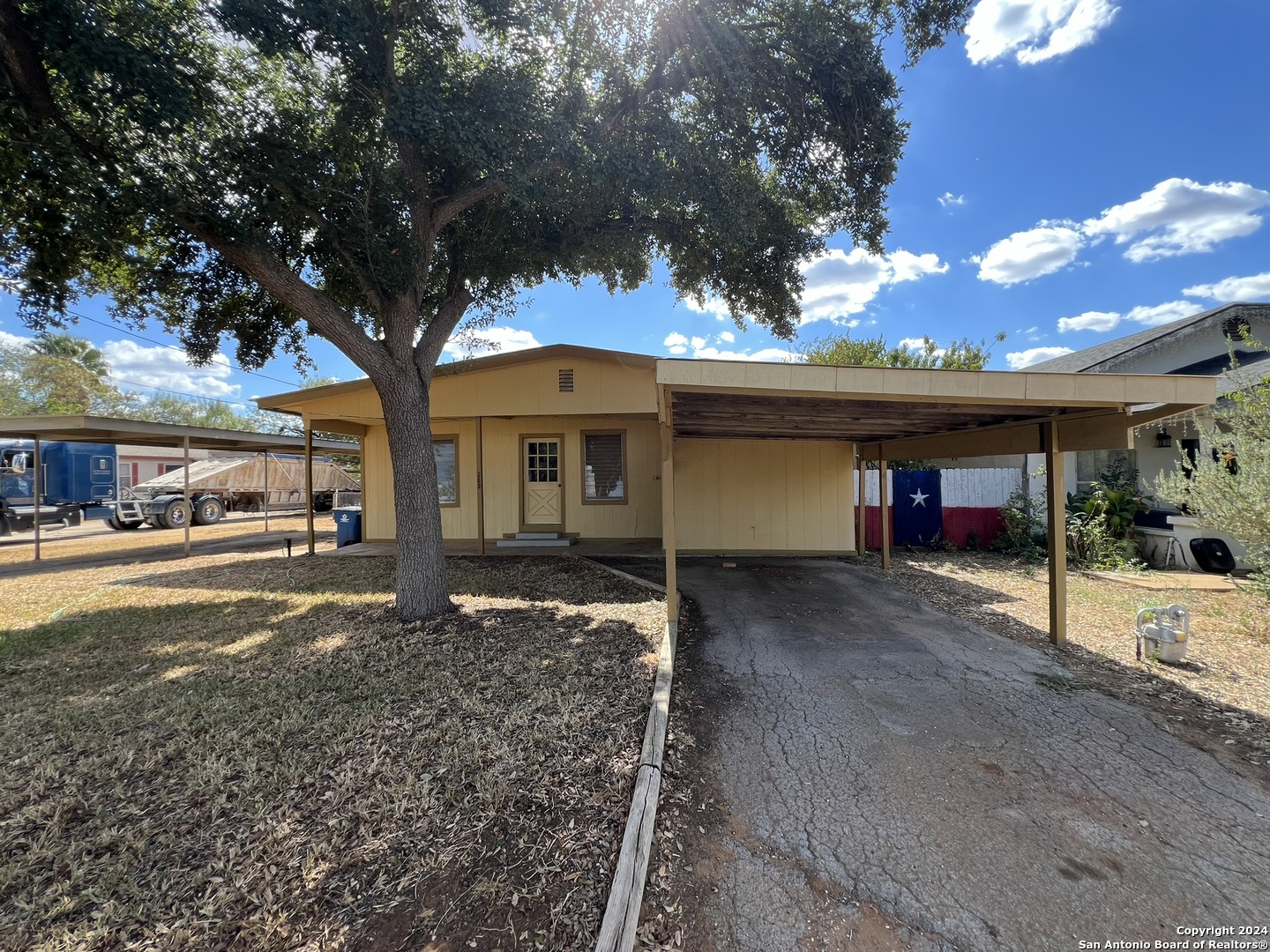 a view of a house with a tree next to a yard