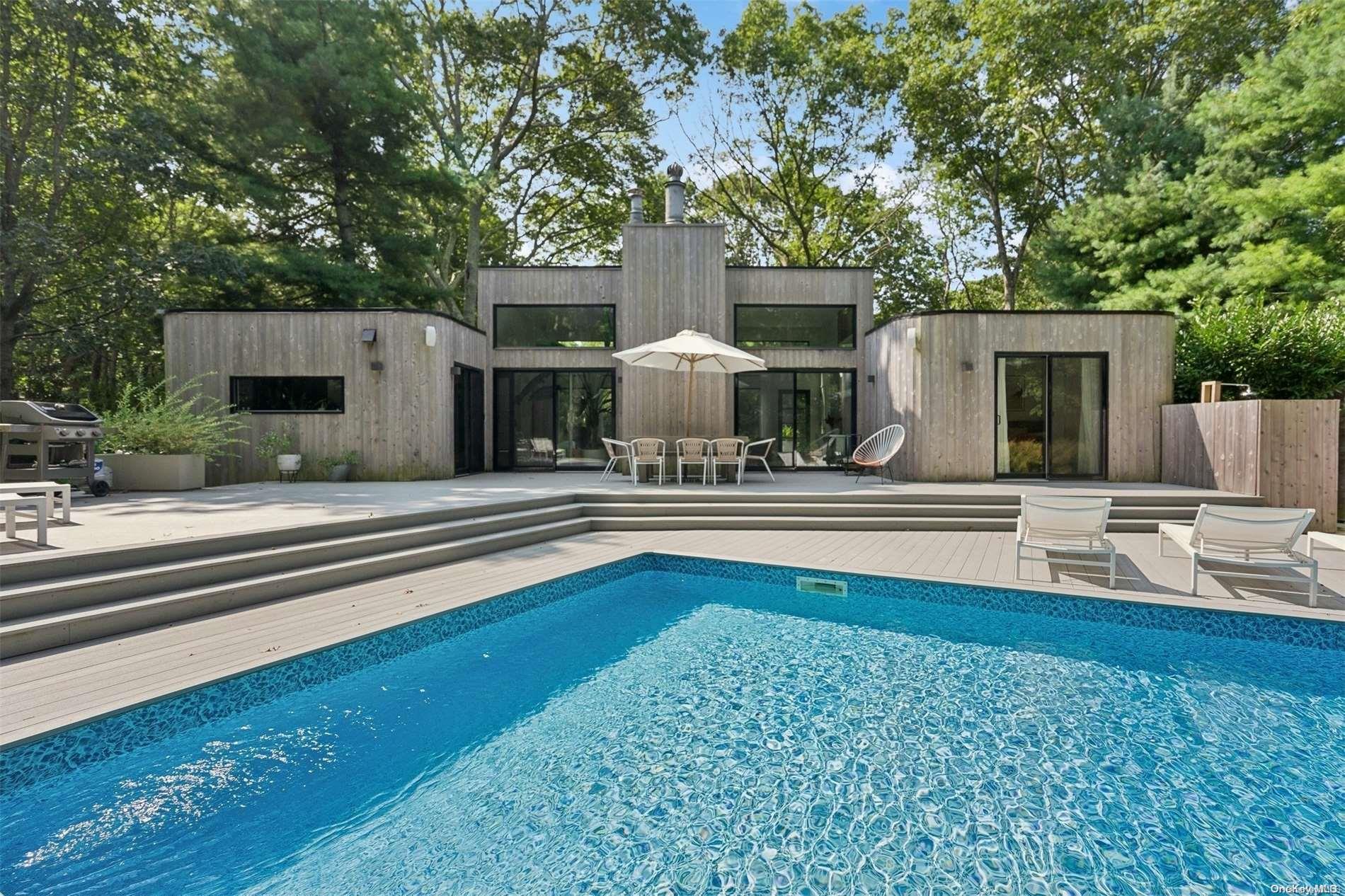 a view of a house with pool and chairs