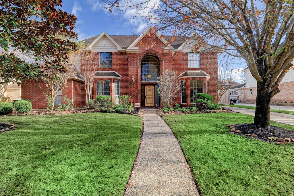 front view of a brick house with a yard