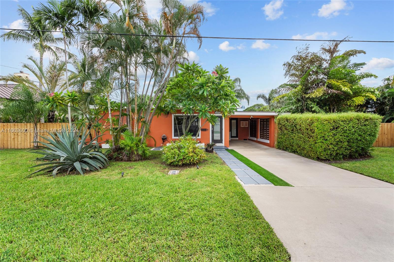 a front view of a house with a yard and potted plants