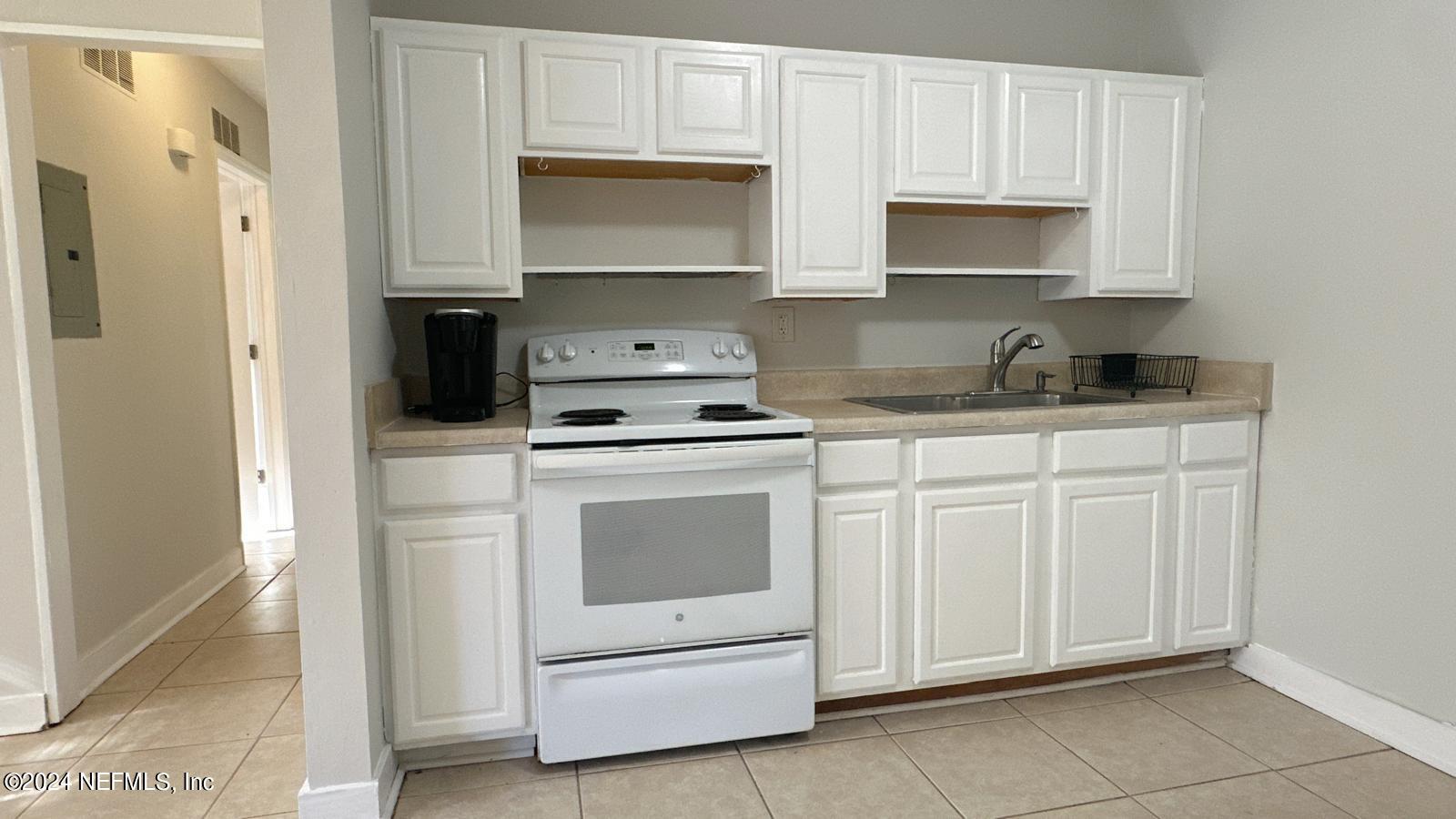 a kitchen with white cabinets and white appliances