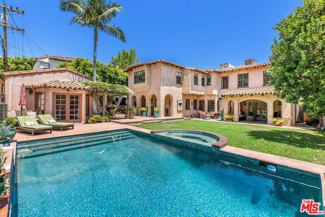 a front view of a house with swimming pool having outdoor seating