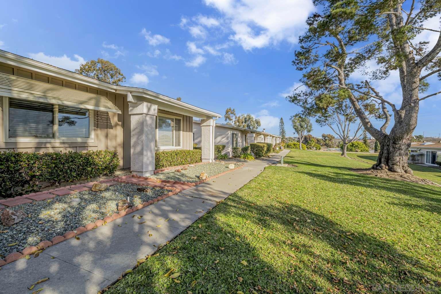 a view of a house with a yard and pathway