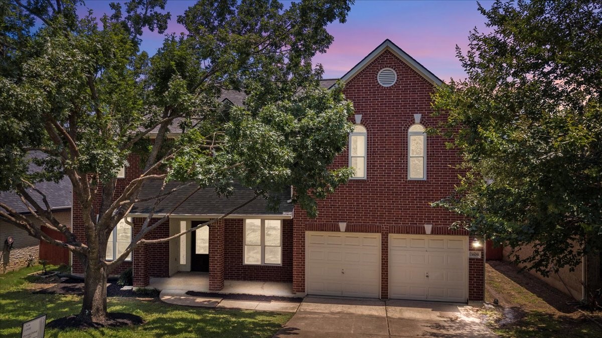 a front view of a house with a tree