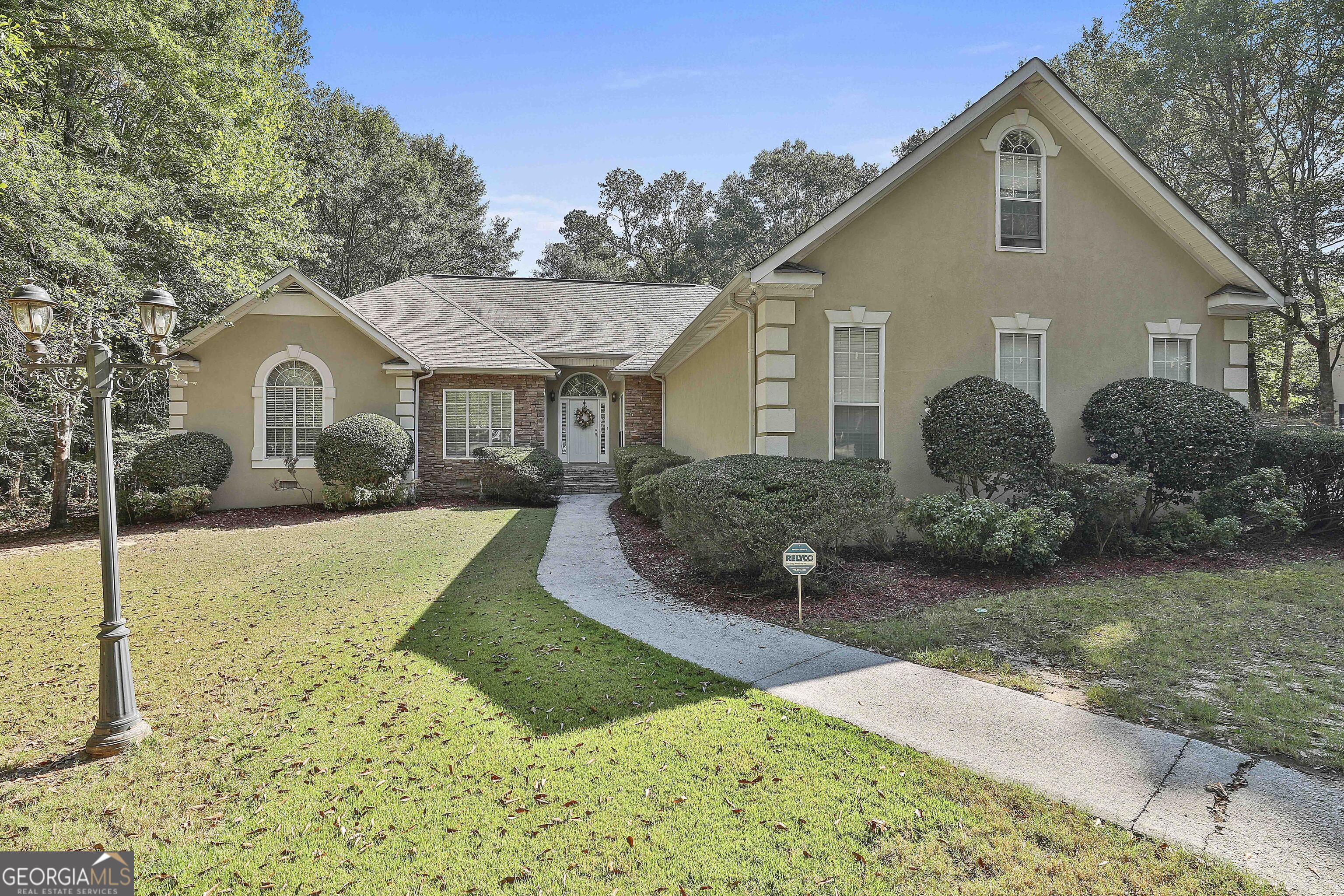 a front view of a house with yard and green space