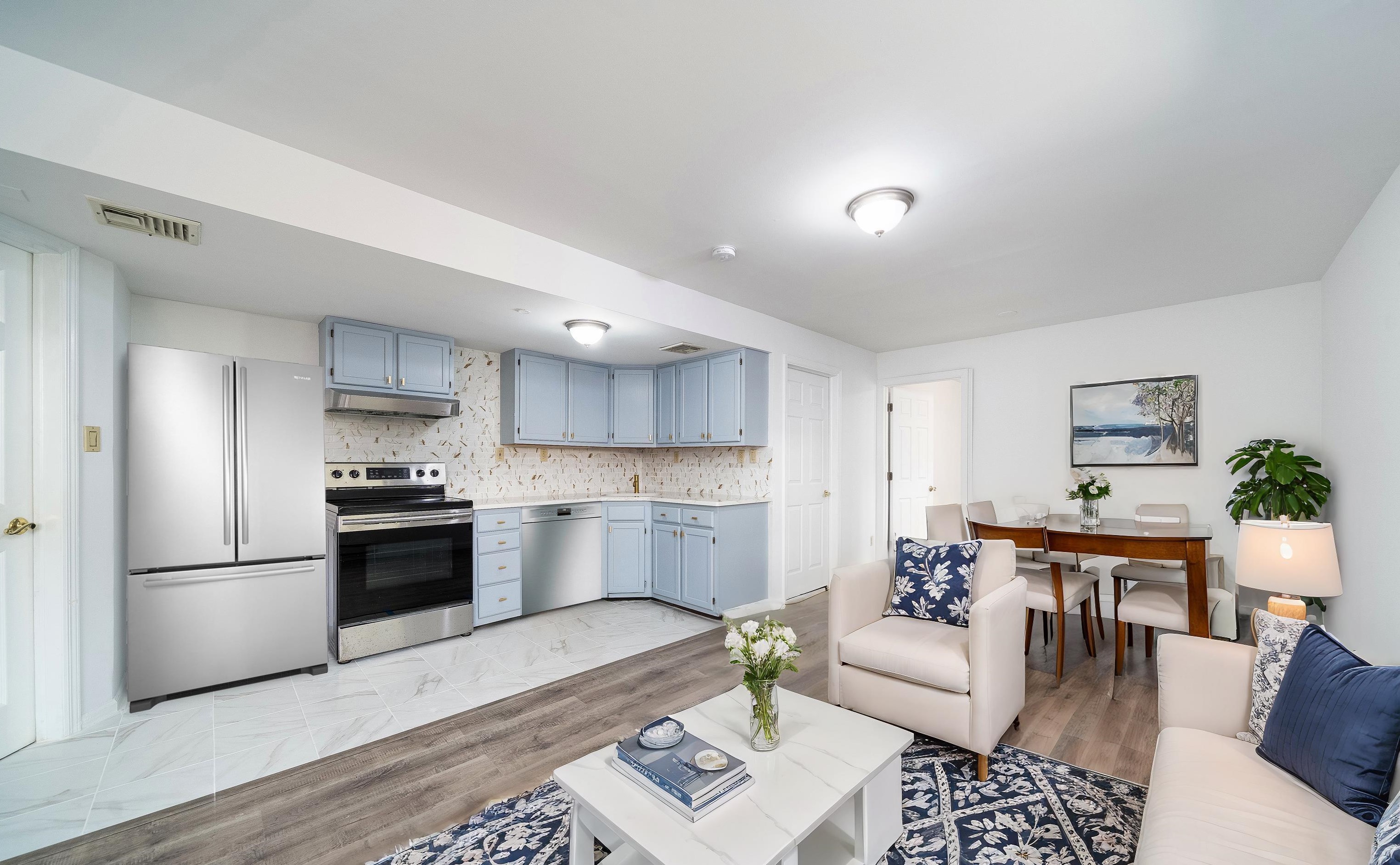 a living room with stainless steel appliances kitchen island granite countertop furniture wooden floor and a view of kitchen