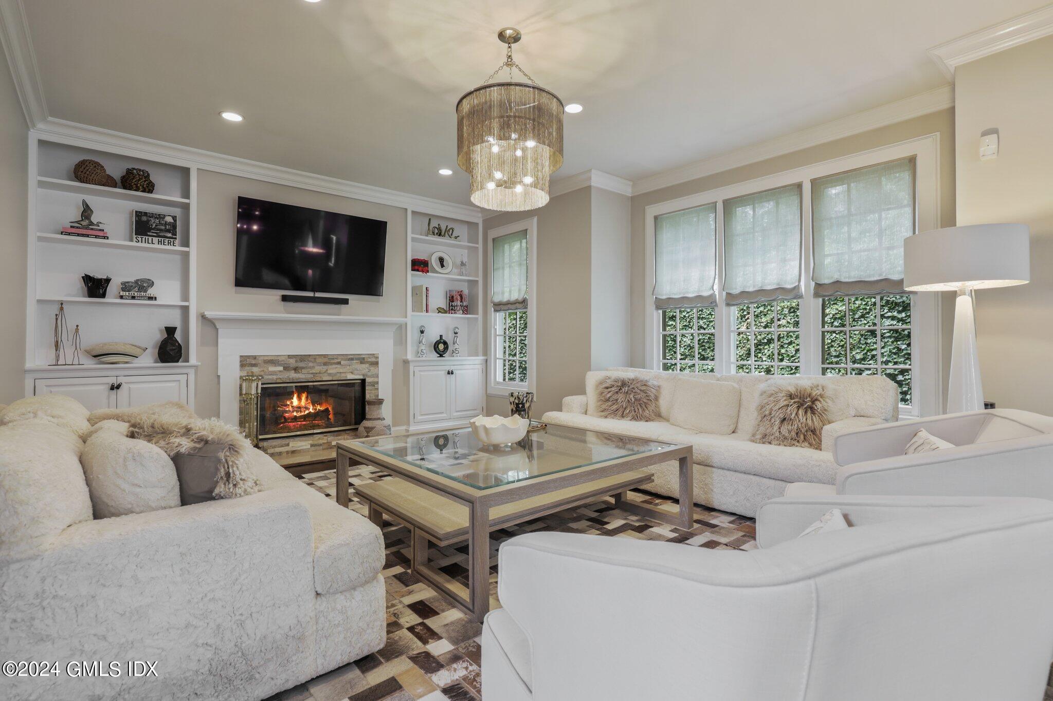 a living room with furniture a flat screen tv and a fireplace