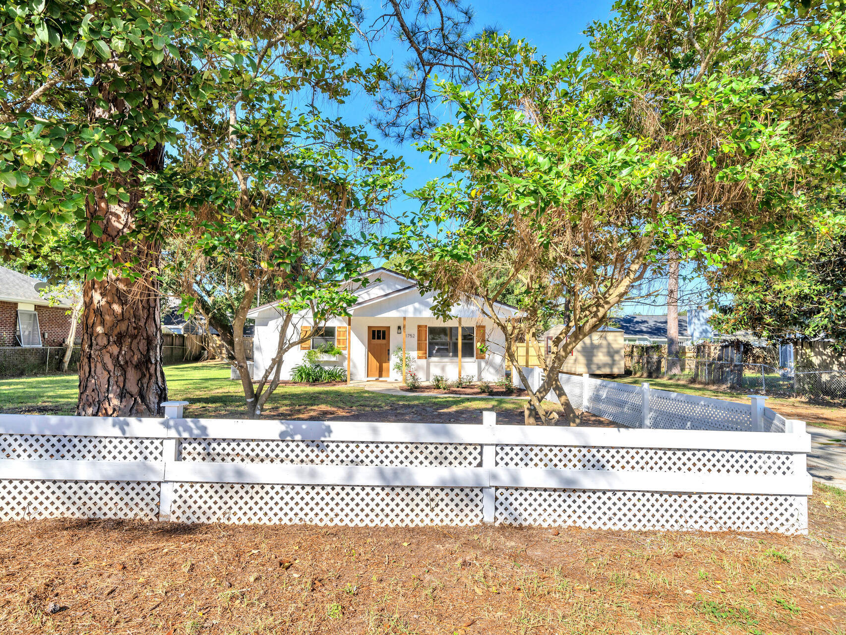 a front view of a house with a tree