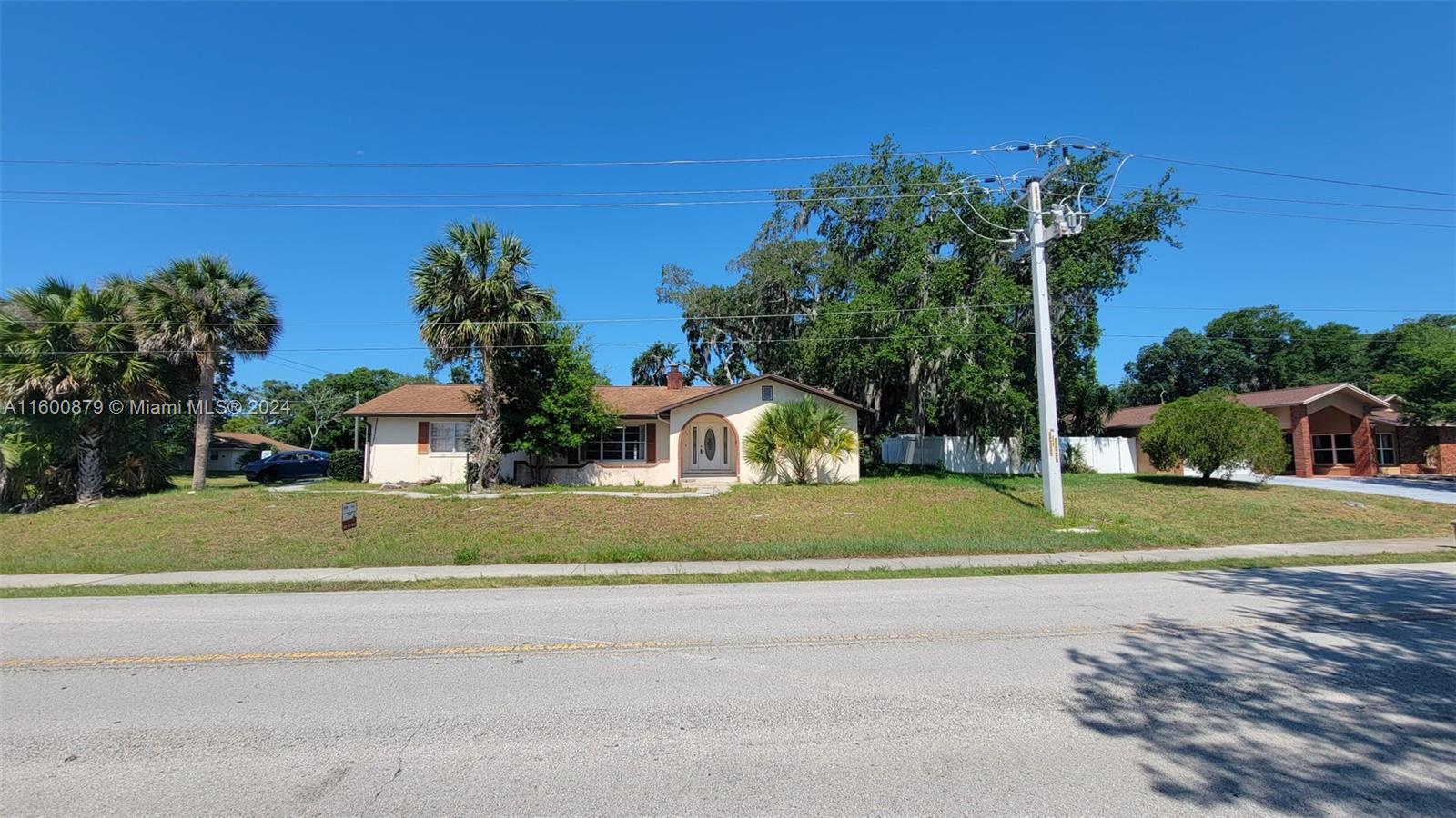 a front view of a house with a yard and trees