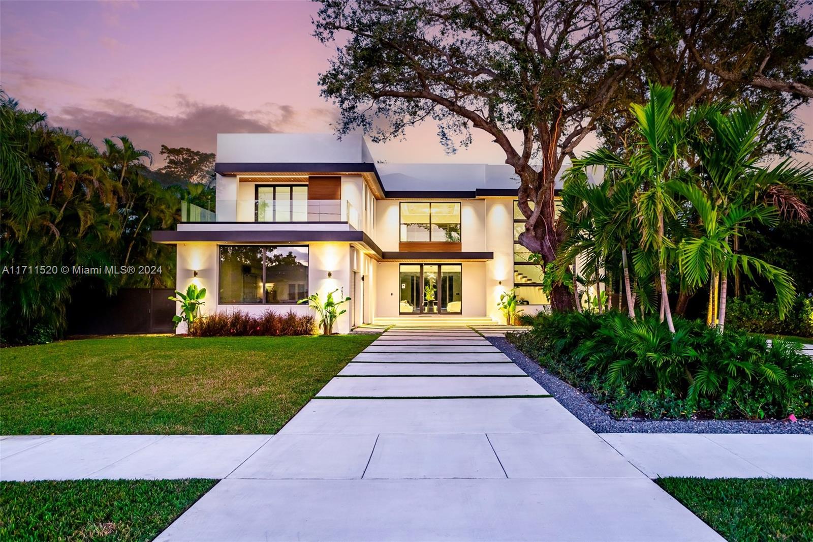 a front view of a house with a yard and trees