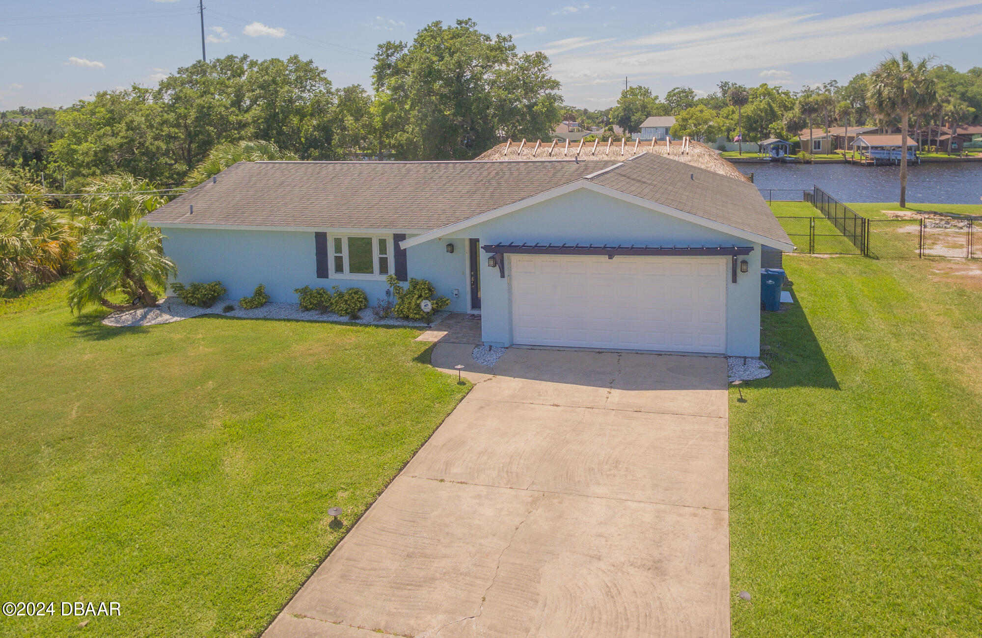 a front view of a house with a yard and lake view