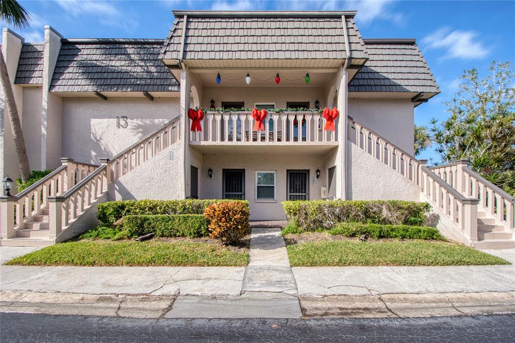 a front view of a house with a yard and potted plants