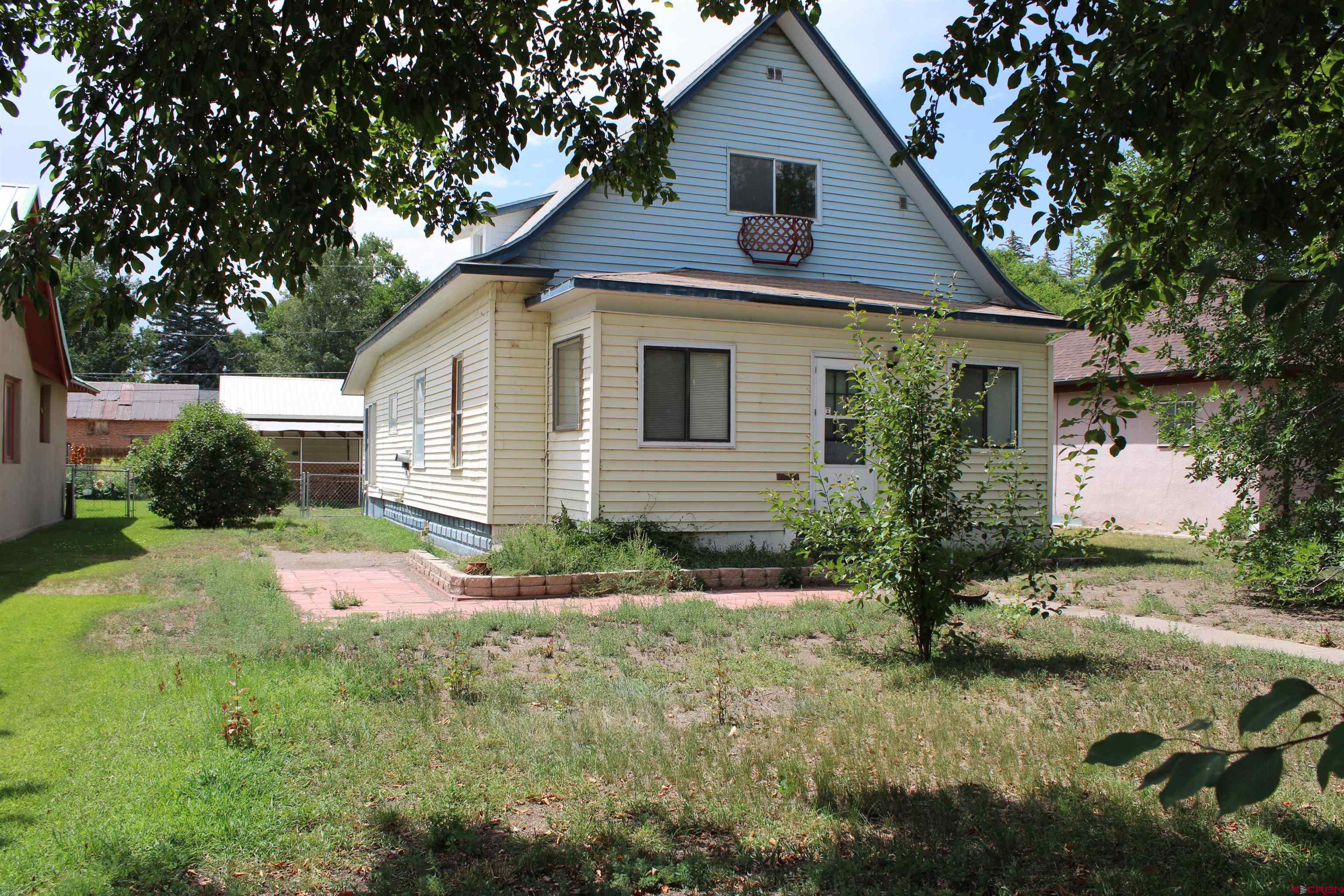 a front view of house with yard and trees around