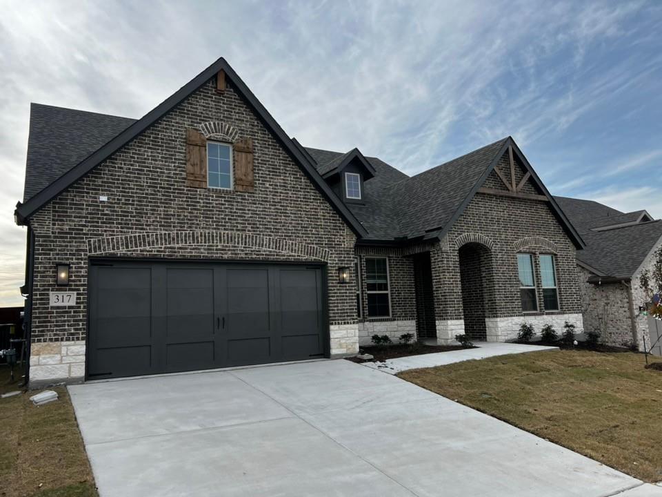 a front view of a house with a yard and garage