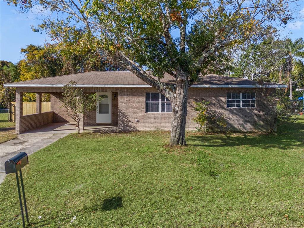 a view of a house with backyard and a tree