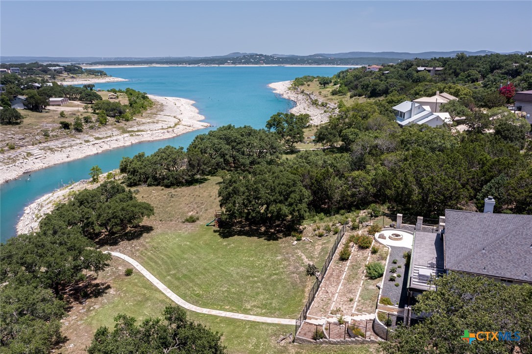 an aerial view of a house with a yard and lake view