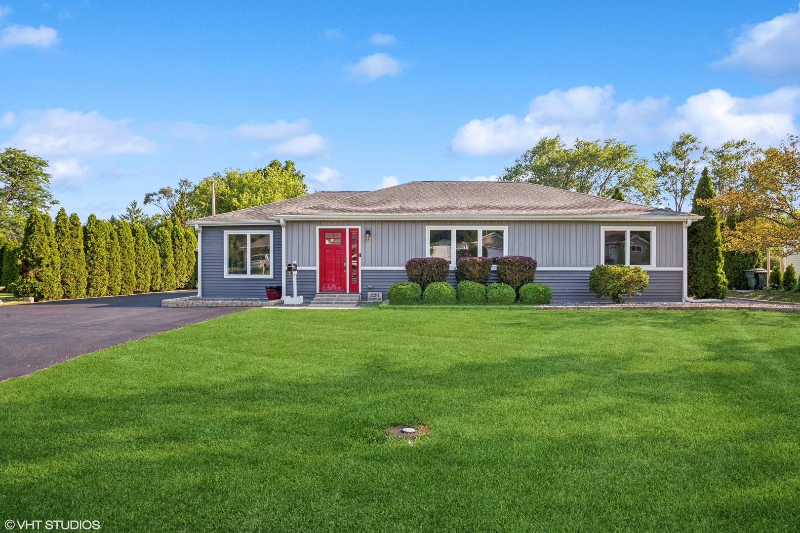 a front view of a house with a garden and yard