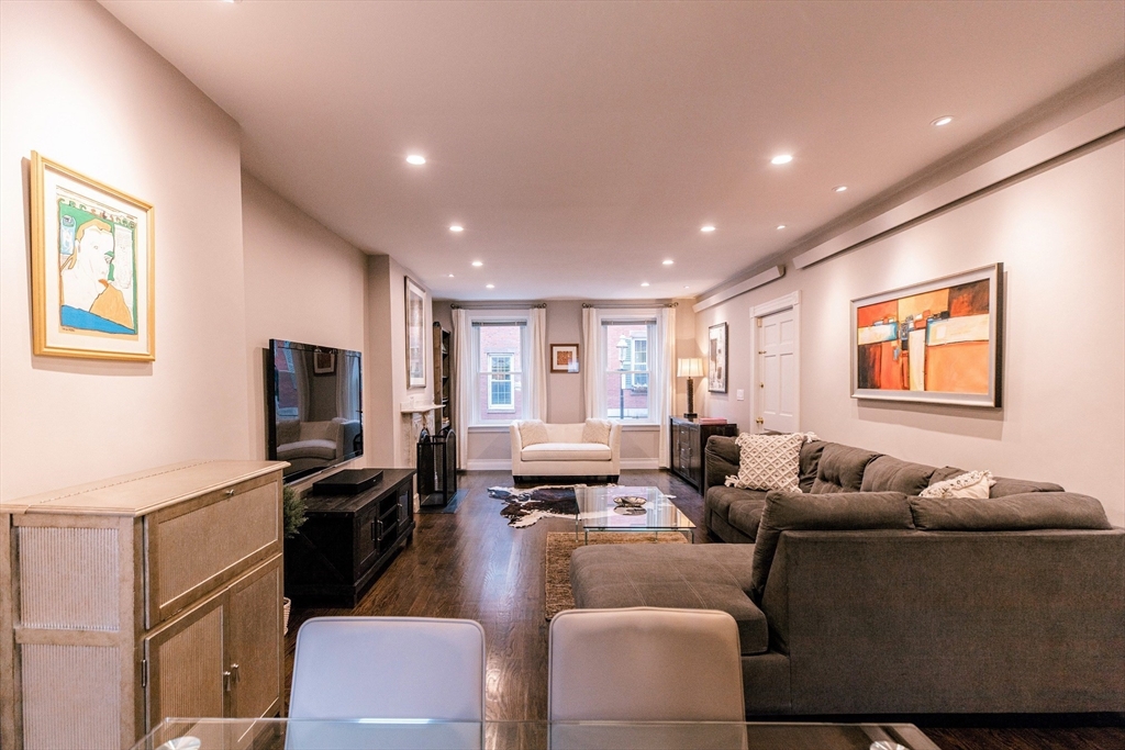 a living room with furniture kitchen view and a window