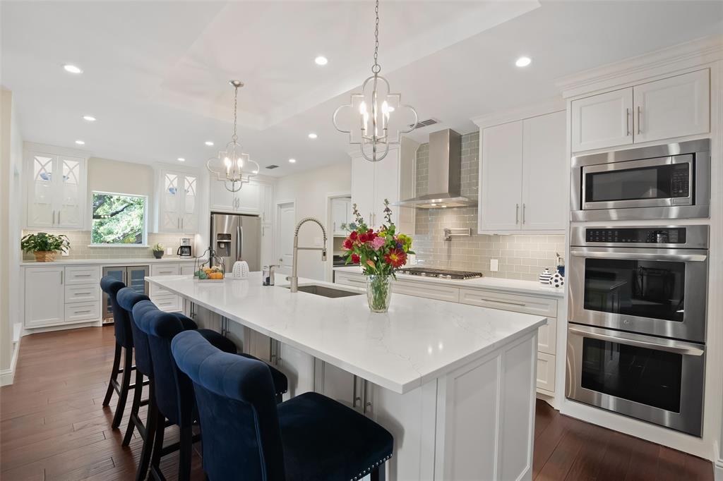 a kitchen with a dining table chairs stainless steel appliances and cabinets