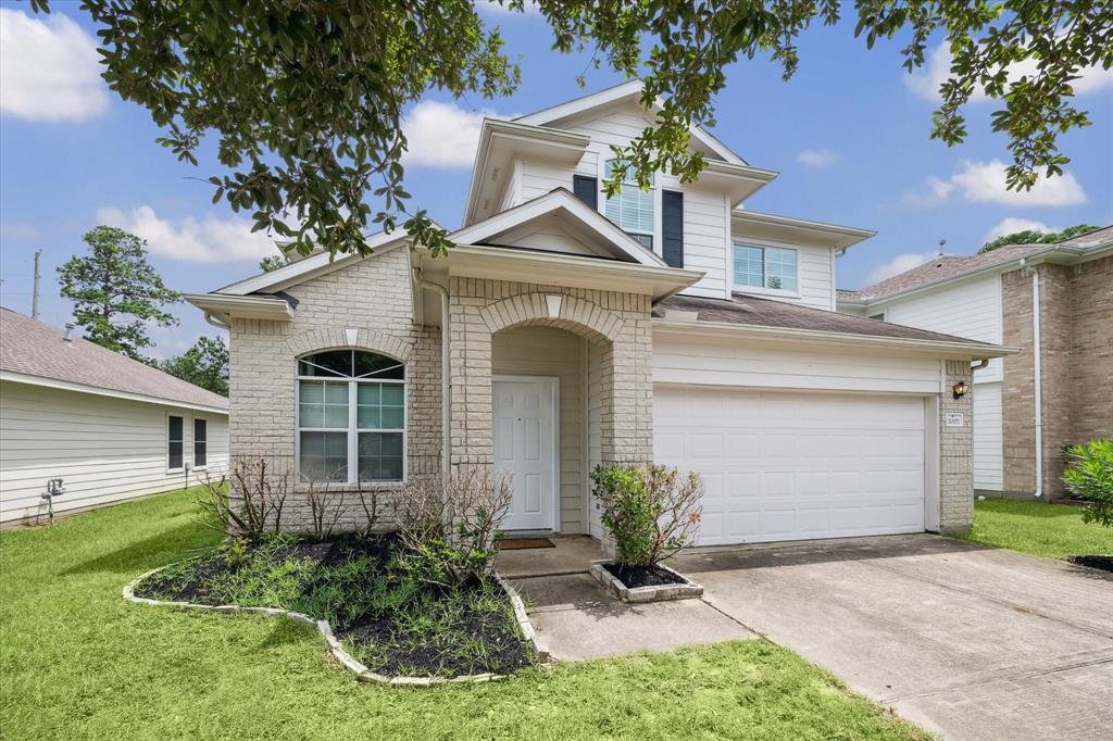 a front view of a house with a yard and garage