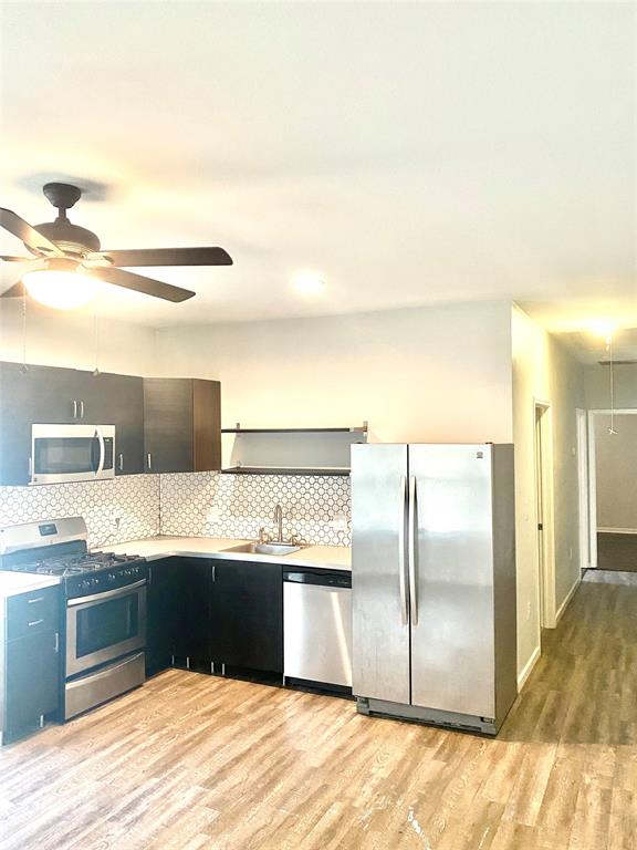 a kitchen with kitchen island granite countertop a refrigerator and a sink