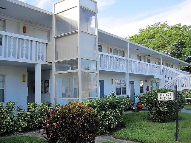 a front view of a building with a garden