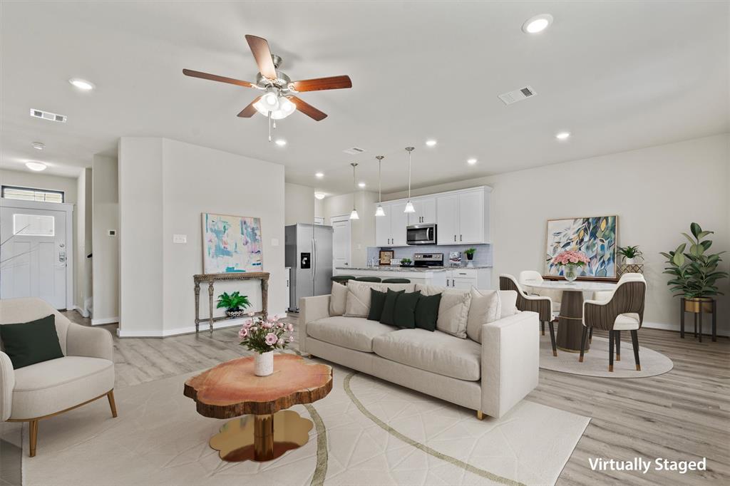 a living room with furniture and a dining table with kitchen view