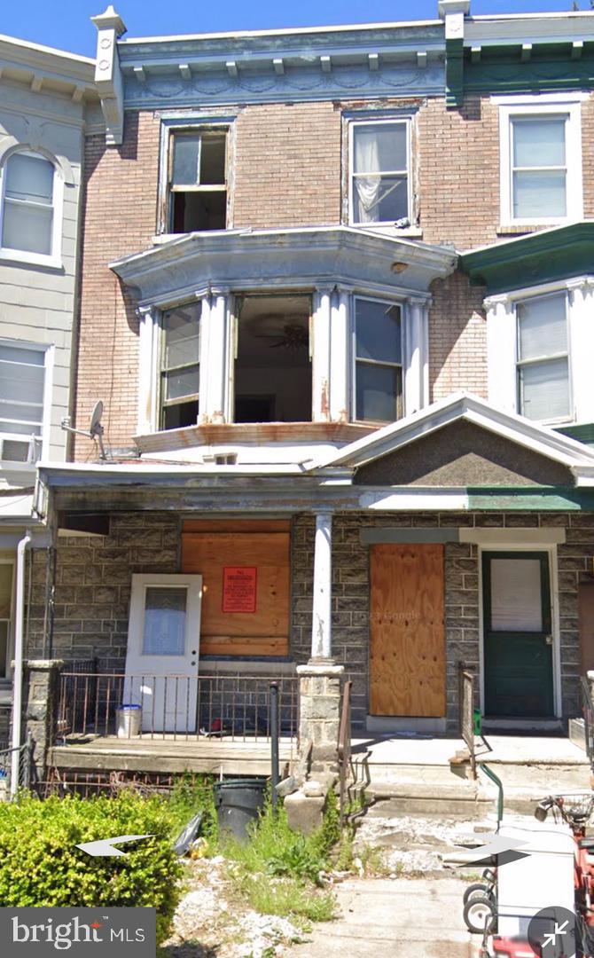 a front view of a house with lots of windows and plants