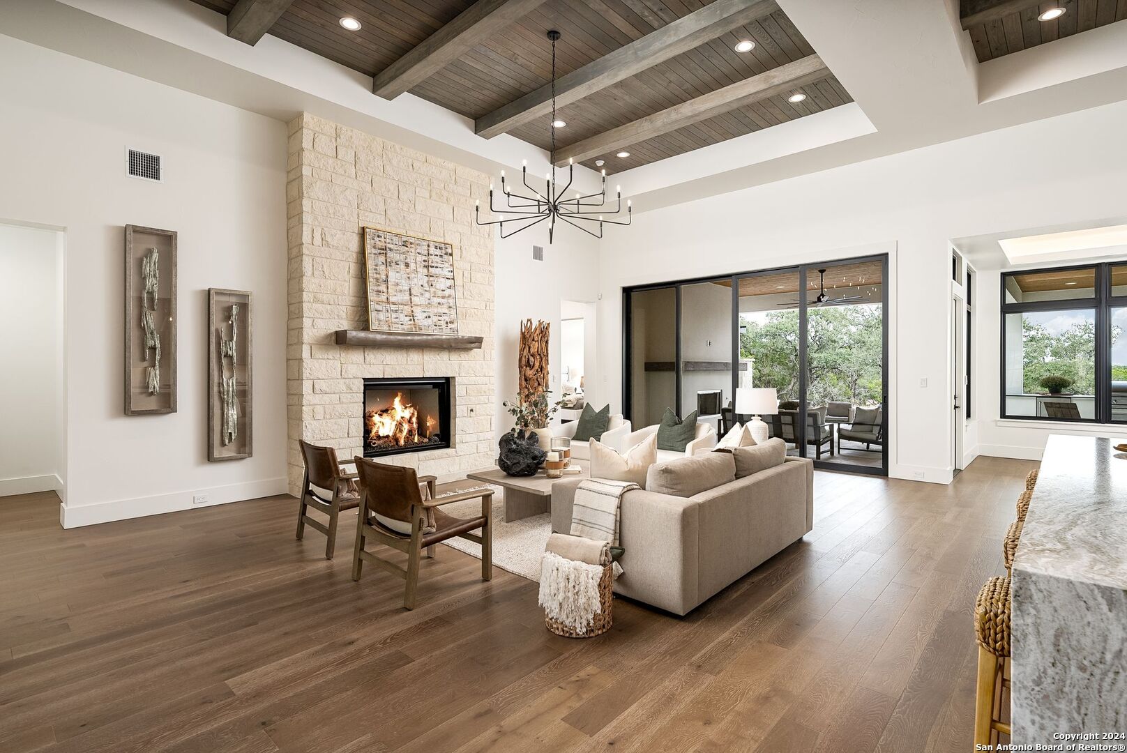 a living room with furniture large window and wooden floor