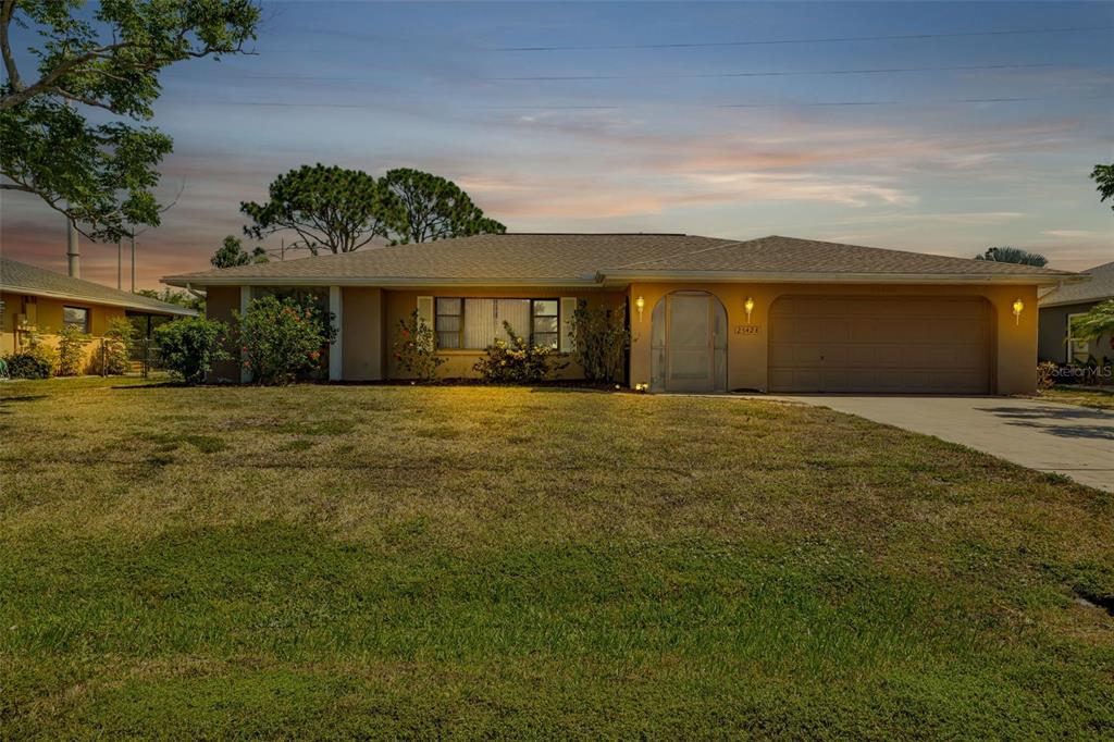 a front view of house with yard and trees in the background