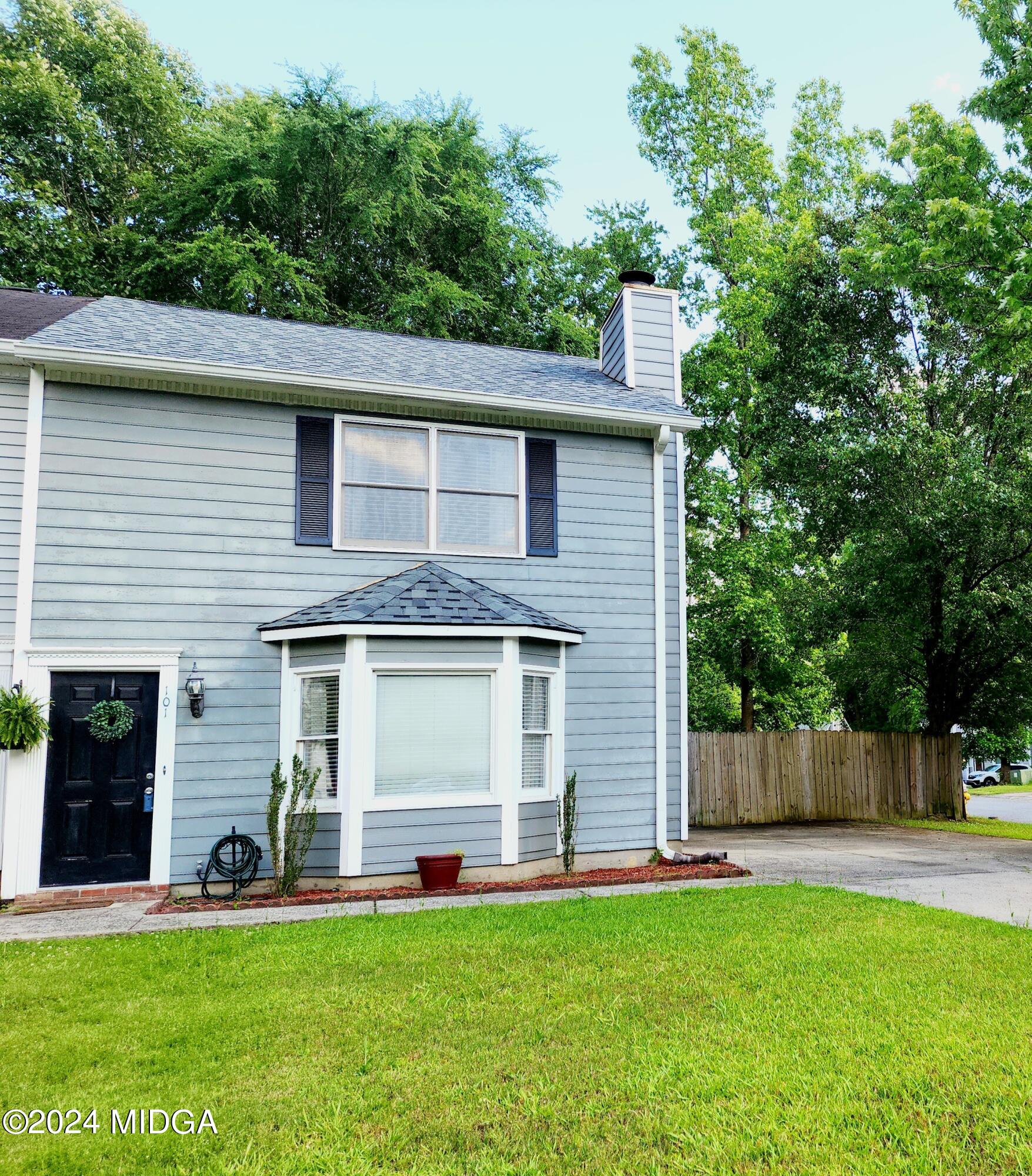 a front view of a house with a garden and yard