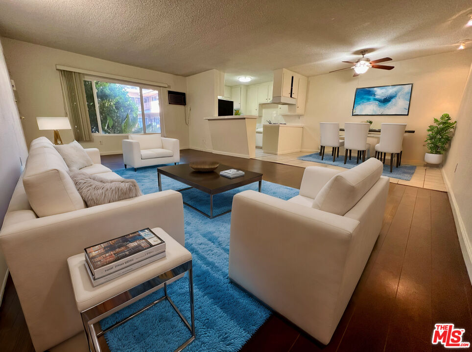 a living room with furniture a rug and a wall painting