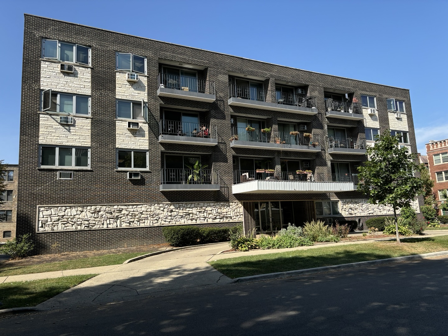 a front view of a building with a garden