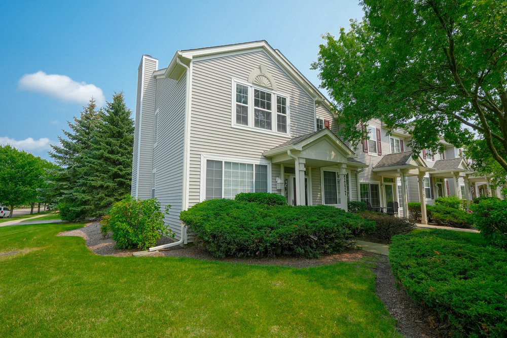 a front view of a house with a yard and trees