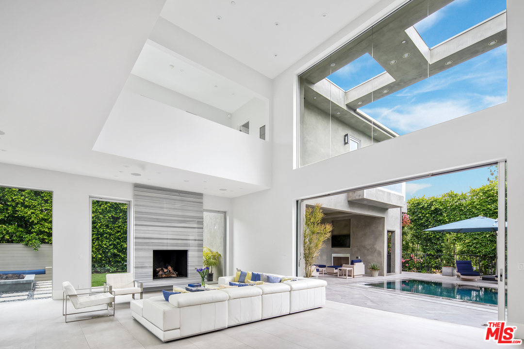 a living room with furniture fireplace and a large window