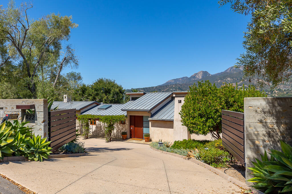 a front view of a house with a yard and mountain view