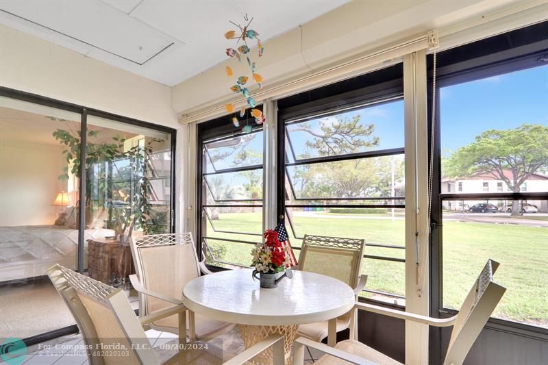 a dining room with furniture water view and a floor to ceiling window