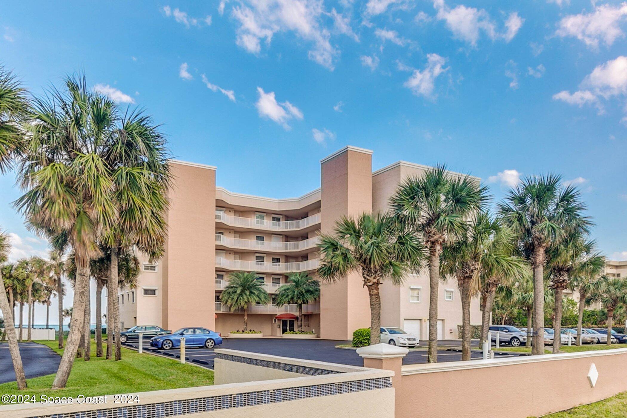 a front view of multi story residential apartment building with yard and outdoor space