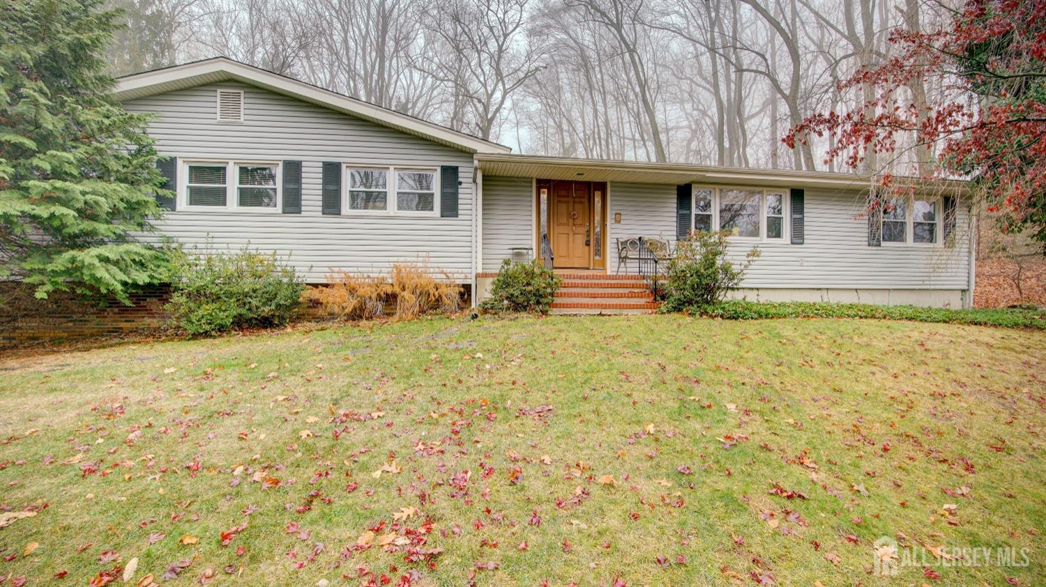 a front view of house with yard and trees around