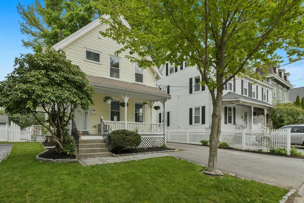 a front view of a house with a garden and yard