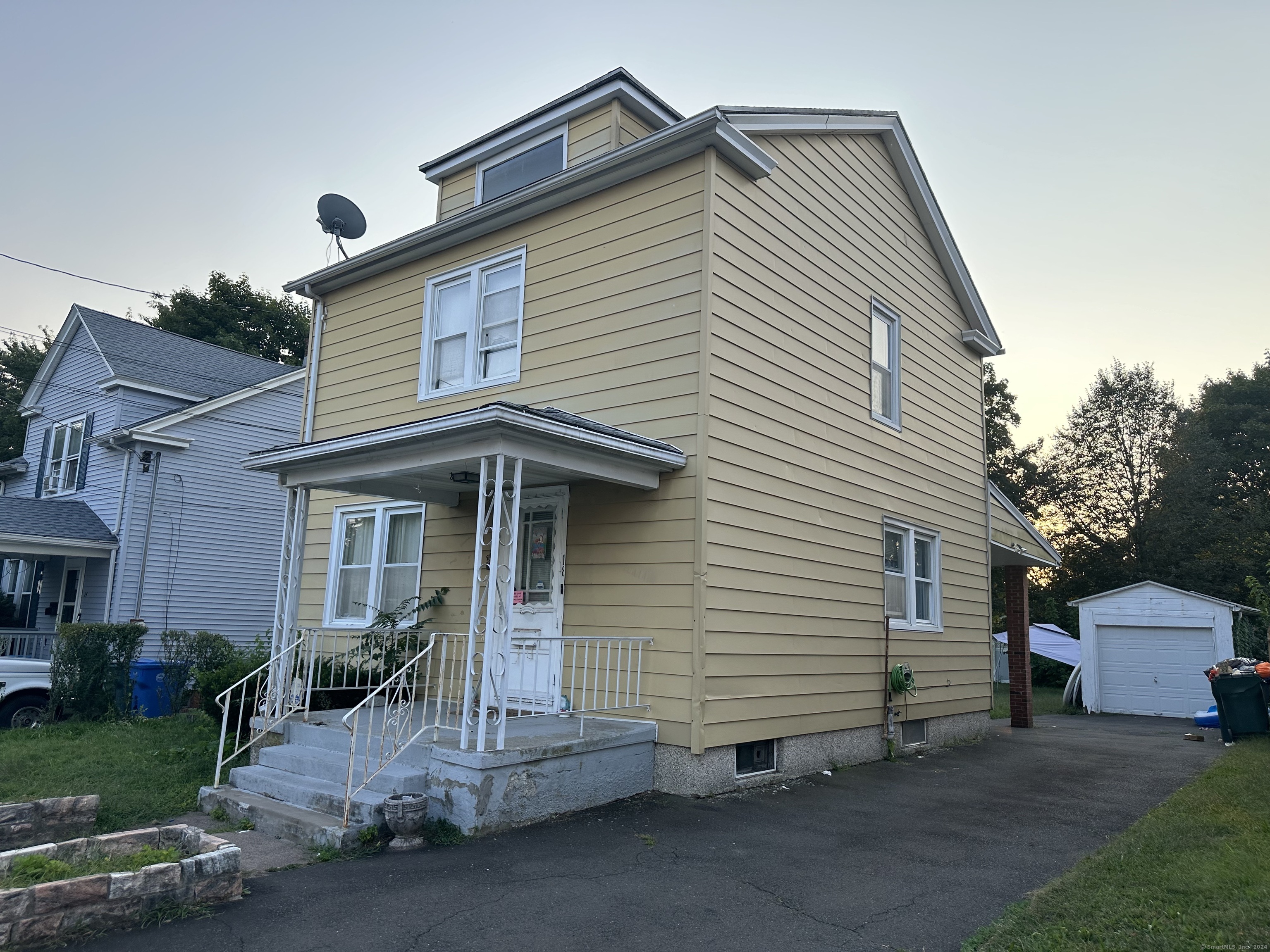 a view of a house with a yard and lawn chairs