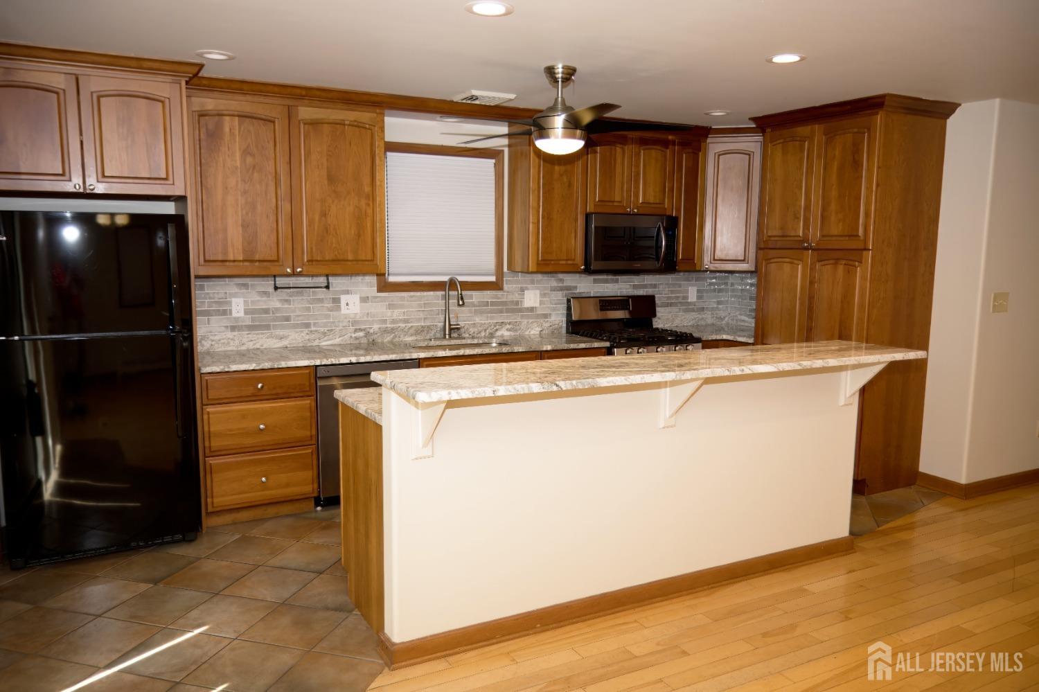 a kitchen with kitchen island granite countertop a sink stove and refrigerator