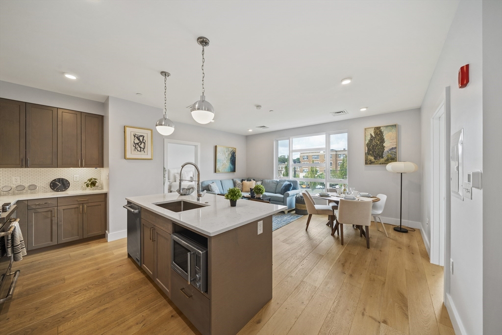 a kitchen with a sink stove and wooden floor