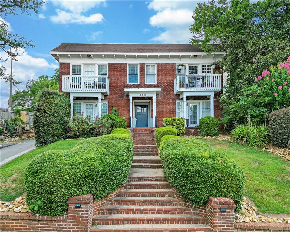 a front view of a house with a garden and plants