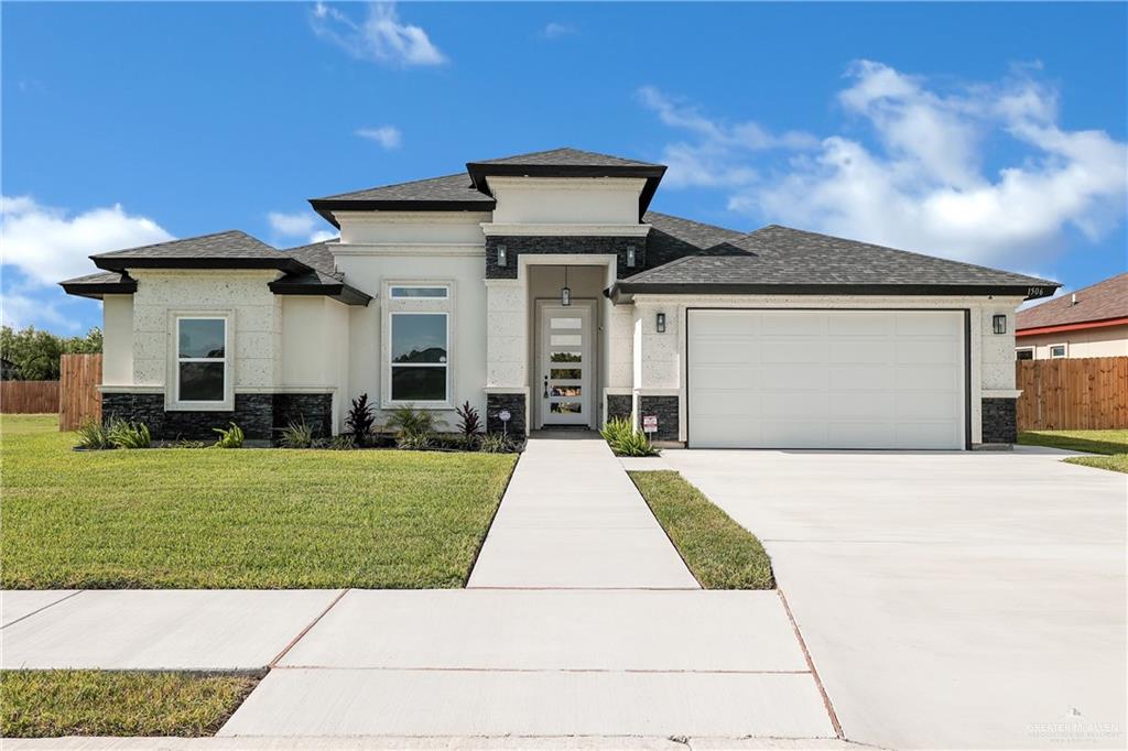 a front view of a house with a yard and garage